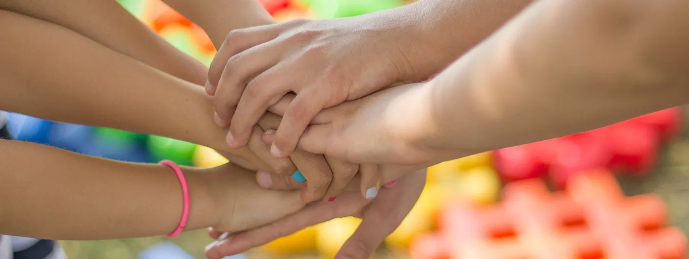 Hands reaching into the center and placed on top of each other